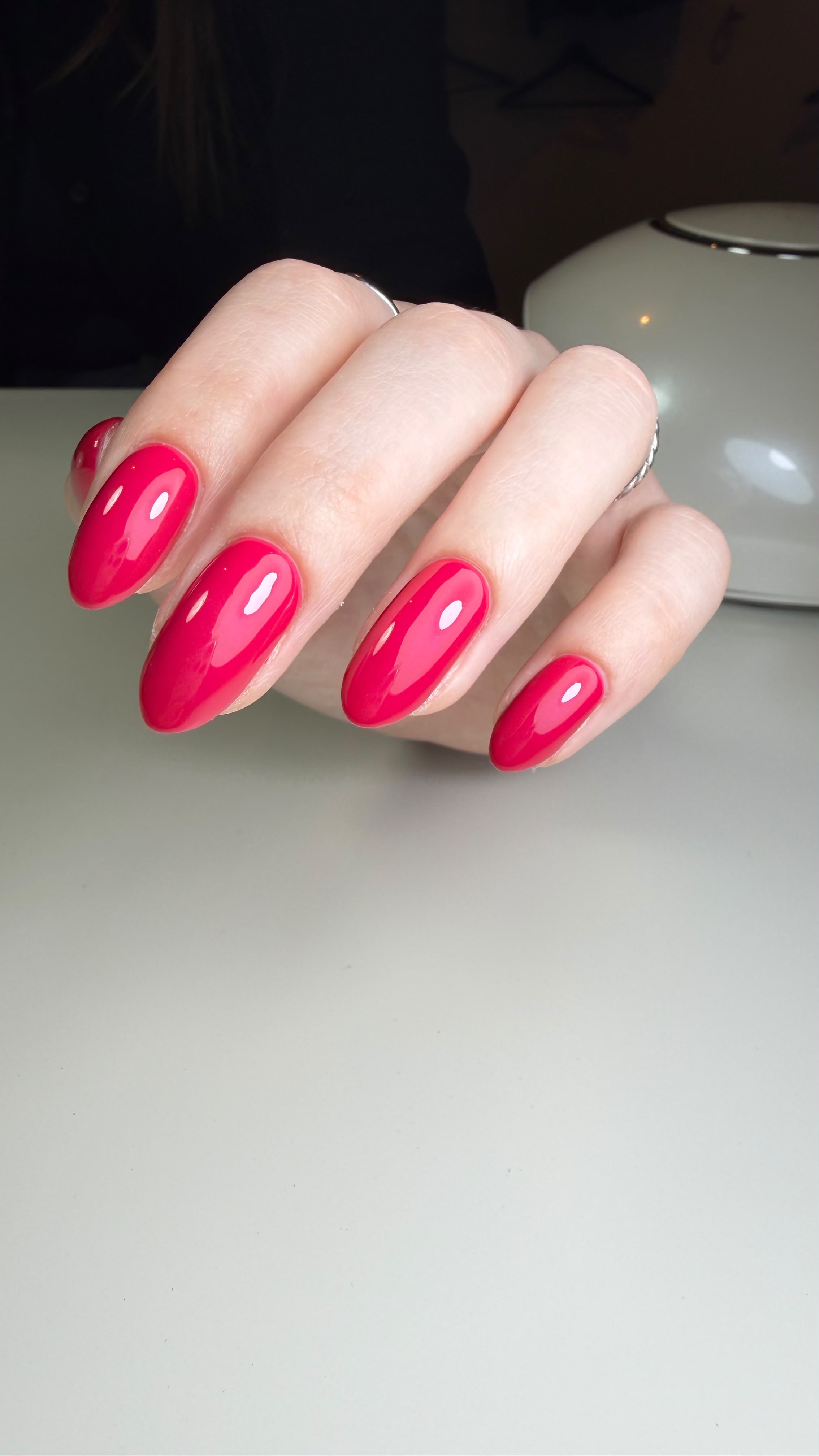 Close-up van amandelvormige nagels in glanzende fuchsia gellak