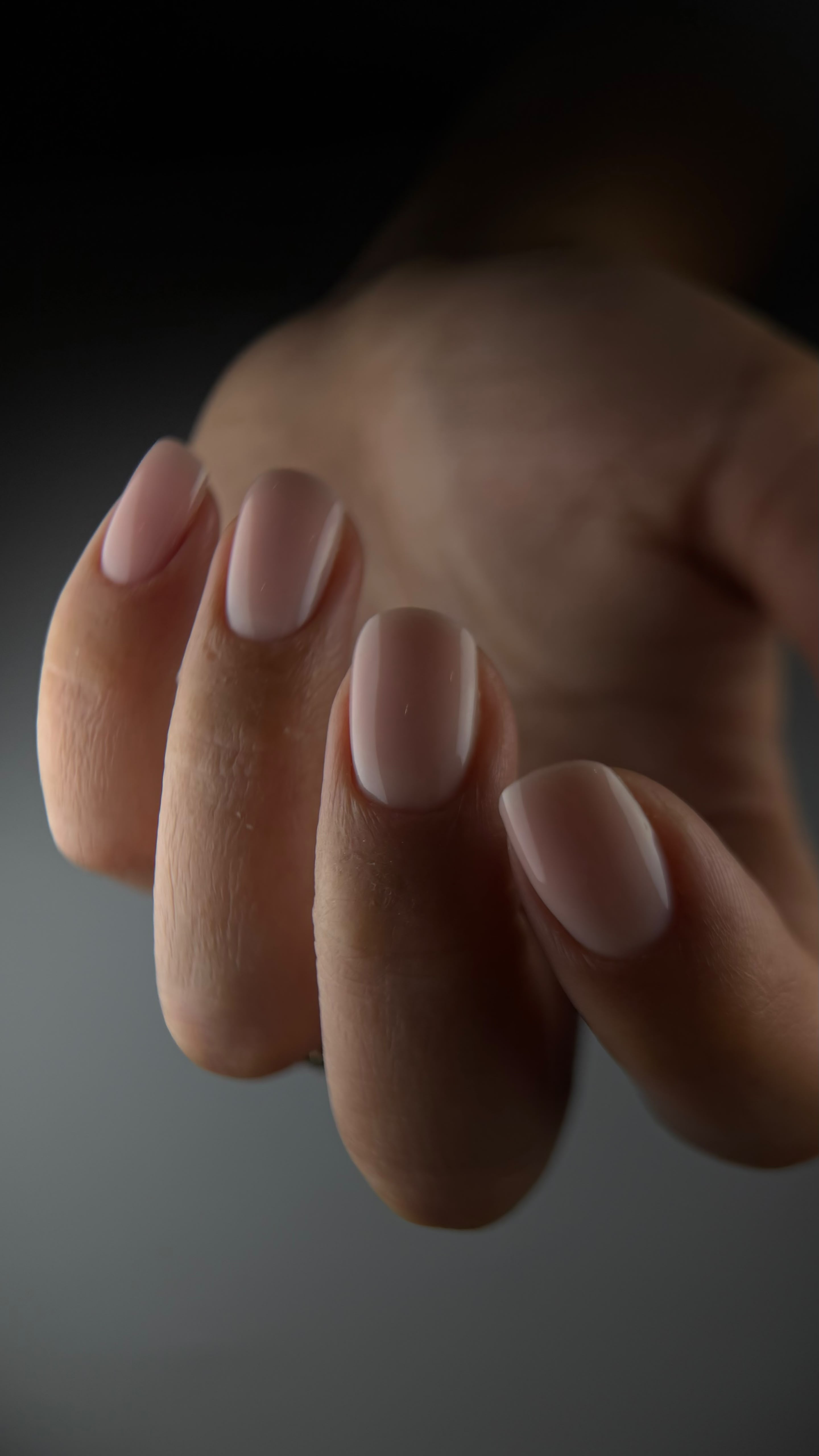 Close-up van ovale nagels in een naturel, glanzende afwerking