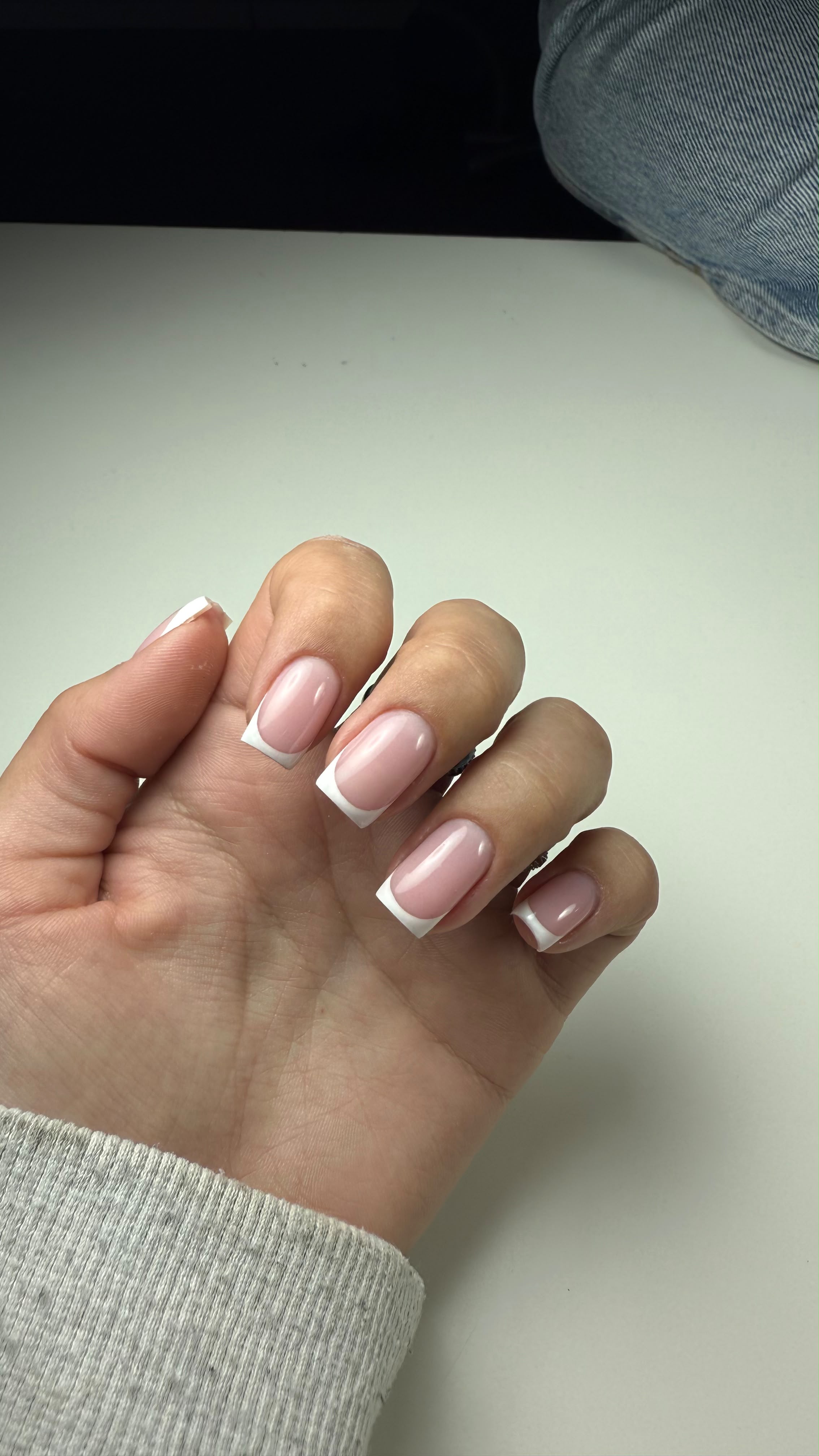 Close-up van vierkante nagels met een klassieke witte French manicure