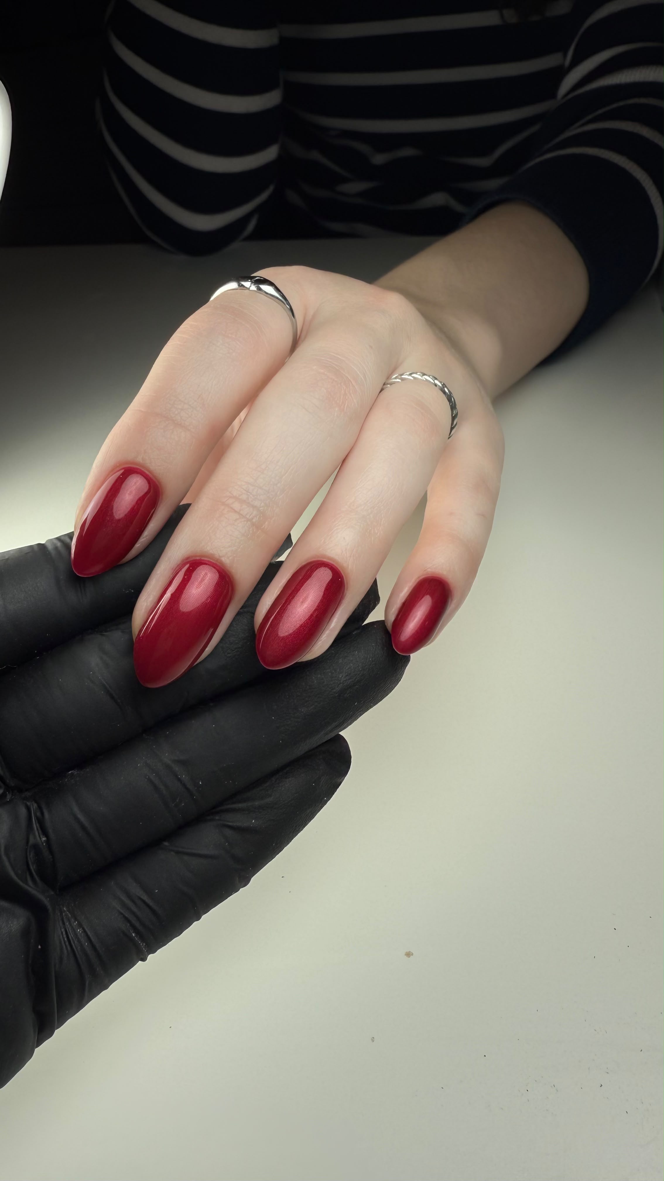 Close-up van amandelvormige nagels in glanzende bordeauxrode gellak