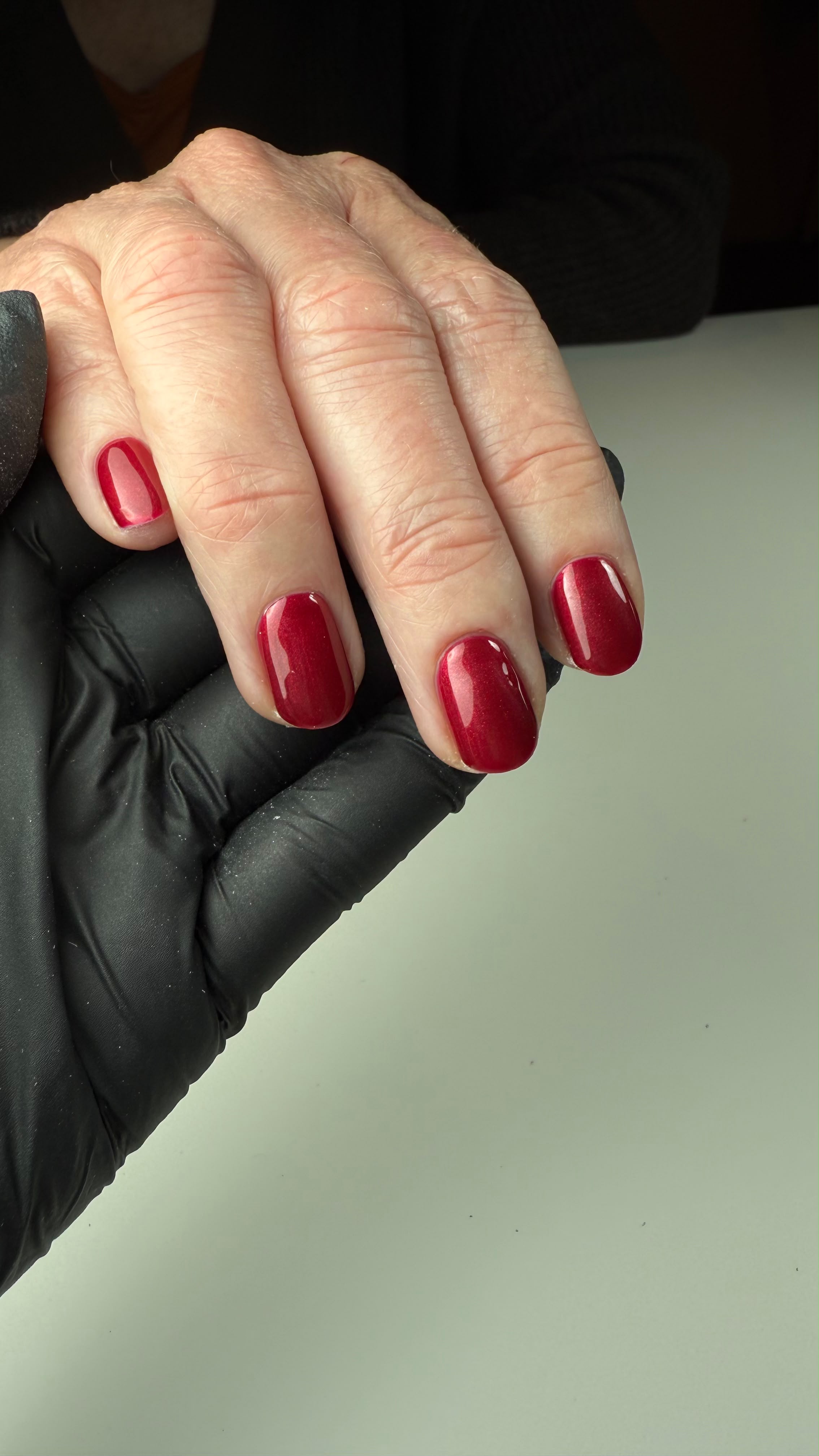 Close-up van ronde nagels in glanzende bordeauxrode gellak